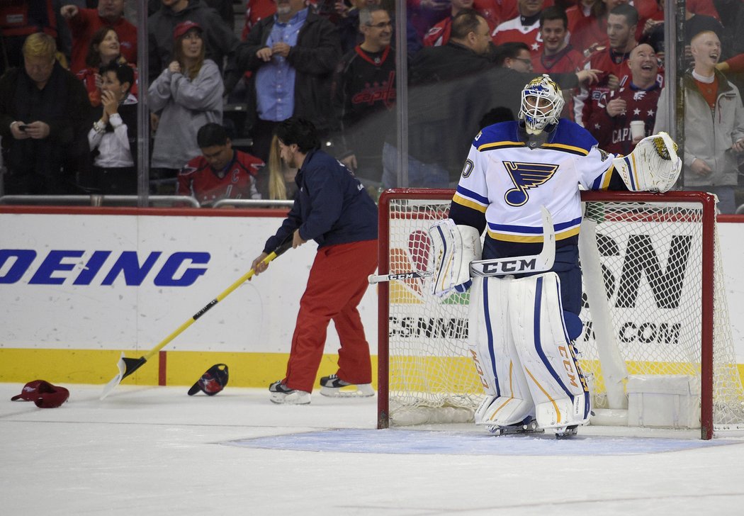 Carter Hutton smutně sleduje, jak jsou z ledové plochy odklízeny čepice po hattricku Alexandra Ovečkina