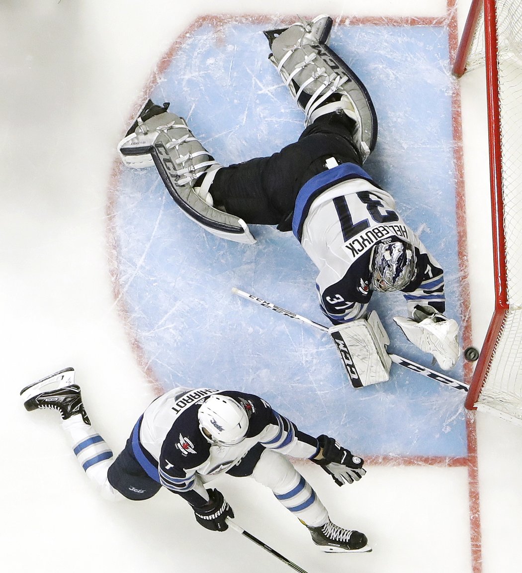 Connor Hellebuyck s obráncem Benem Chiarotem vytlačili tenhle puk mimo bránu