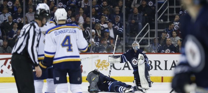 Connory Hellebuyck se sklání nad zraněným spoluhráčem Ehlersem