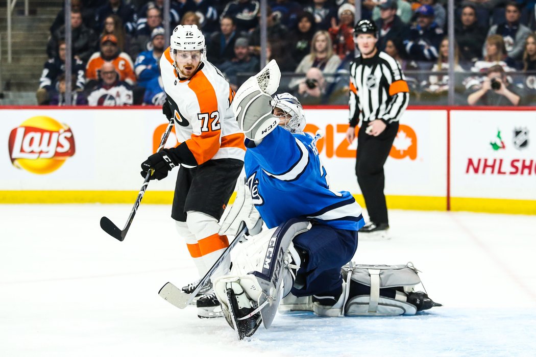 David Kaše sleduje, jak to s lapačkou umí Connor Hellebuyck z Winnipegu