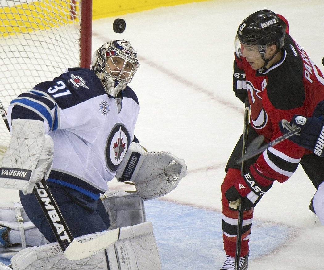 Pavelec zasahuje před kapitánem New Jersey Parisem.