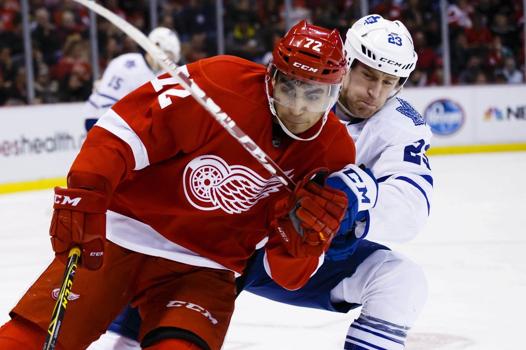 Andreas Athanasiou z Detroitu a Brooks Laich v souboji o puk