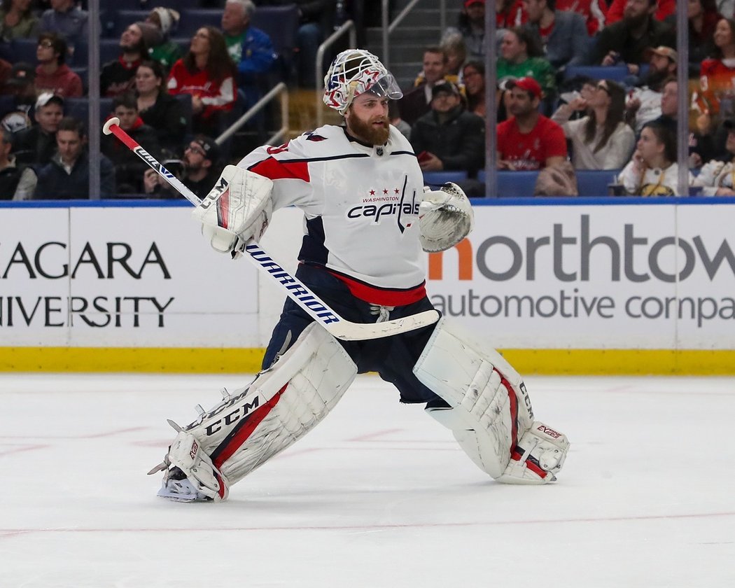 Braden Holtby popadne lahev, vystříkne vodu a sleduje, jak kapky dopadají na ledovou plochu.