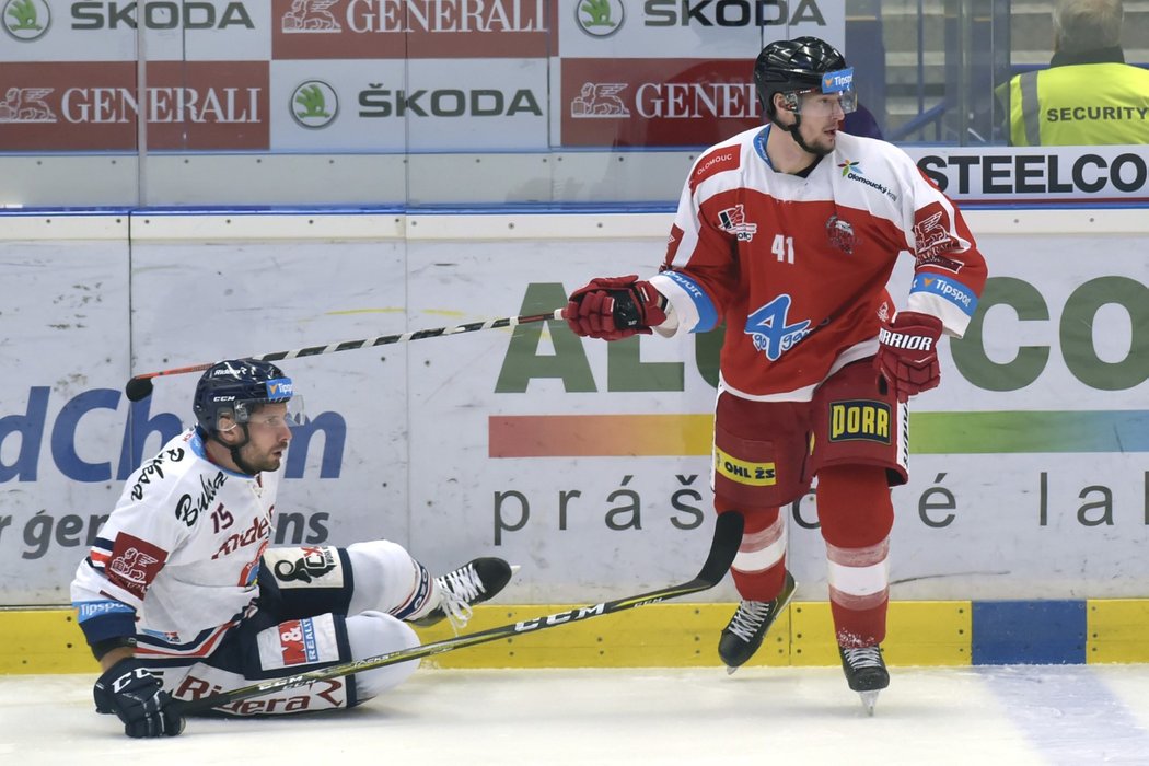 Blaž Gregorc (vlevo) leží na ledě po souboji s Petrem Strapáčem (vpravo) během duelu Vítkovic s Olomoucí