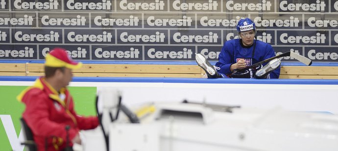 Lukáš Kovář čeká na střídačce, až rolbař připraví led pro český trénink