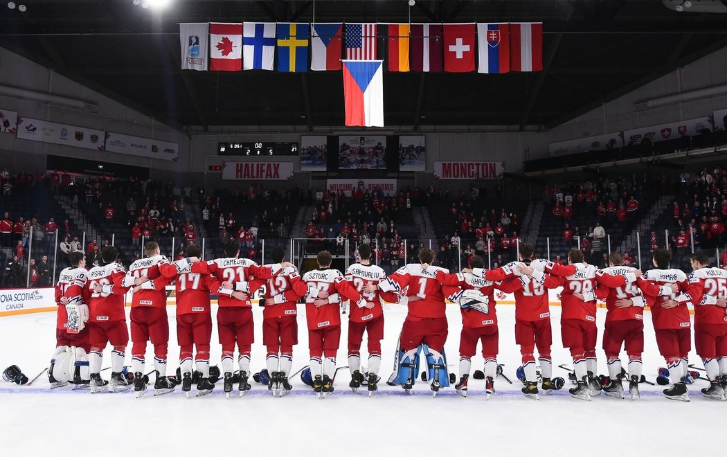 Čeští juniorští hokejisté oslavují senzační vítězství nad Kanadou za poslechu státní hymny