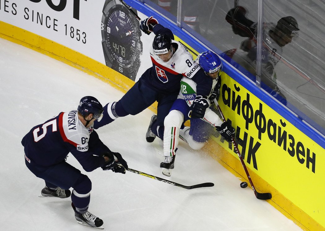 Slovenští hokejisté v boji o puk s italským hráčem Antonem Bernardem