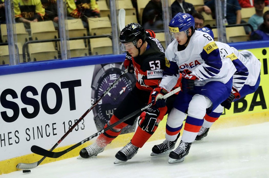 Kanaďan Mathew Barzal soupeří o puk s jihokorejským protivníkem