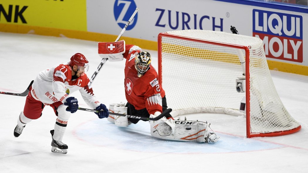 Švýcarský brankář Reto Berra právě inkasuje branku od Alexandera Pavloviče