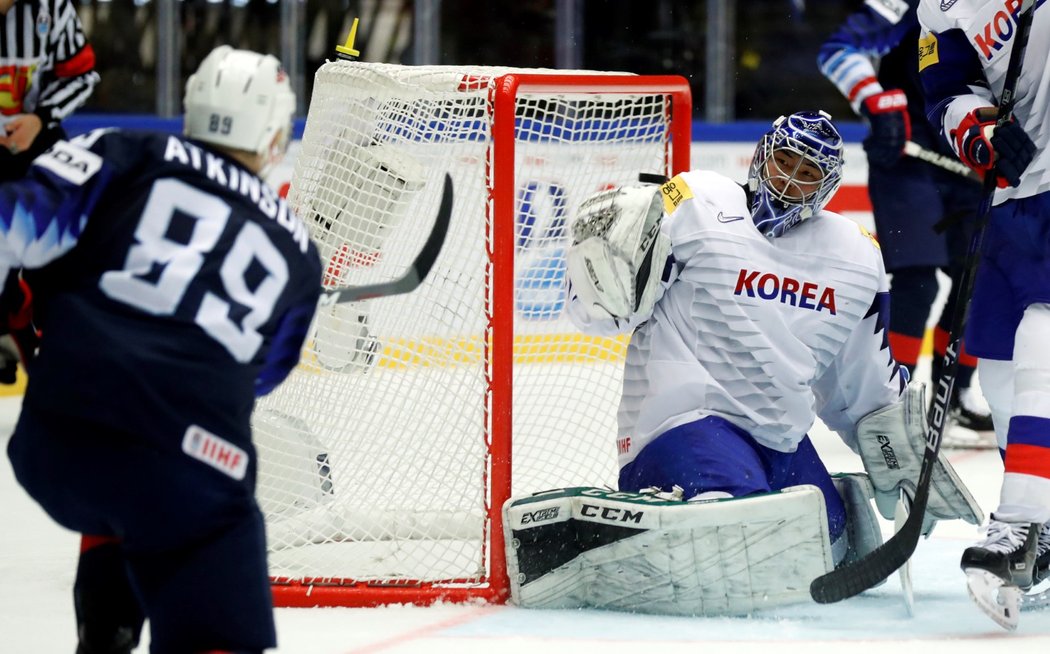 Americký obránce Cam Atkinson překonává jihokorejského brankáře