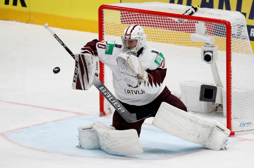 Brankář Lotyšska Kristers Gudlevskis se chystá lapit kotouč