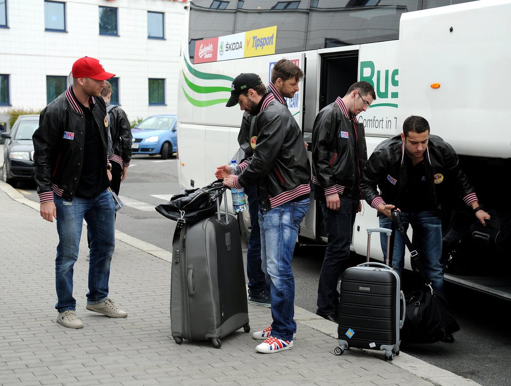 Hokejoví reprezentanti vybalují bagáž z autobus před odletem do Švédska