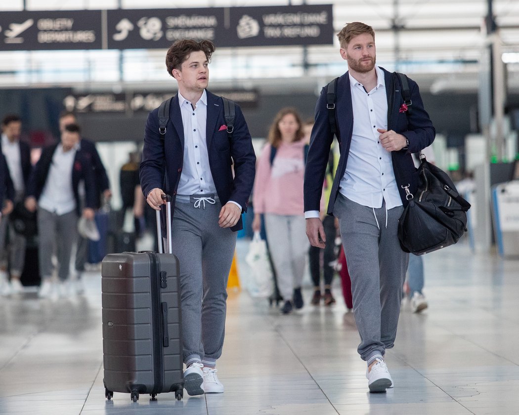 Čeští hokejisté Matěj Blümel (vlevo) a David Musil na letišti