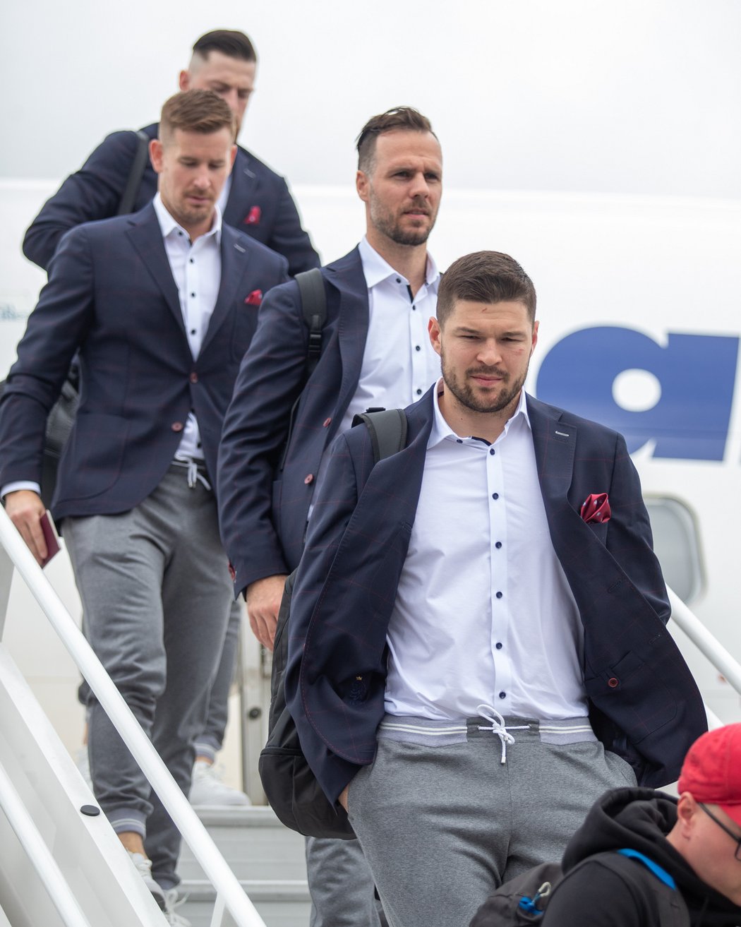 Čeští hokejisté vystupují z letadla po příletu do dějiště mistrovství světa ve Finsku