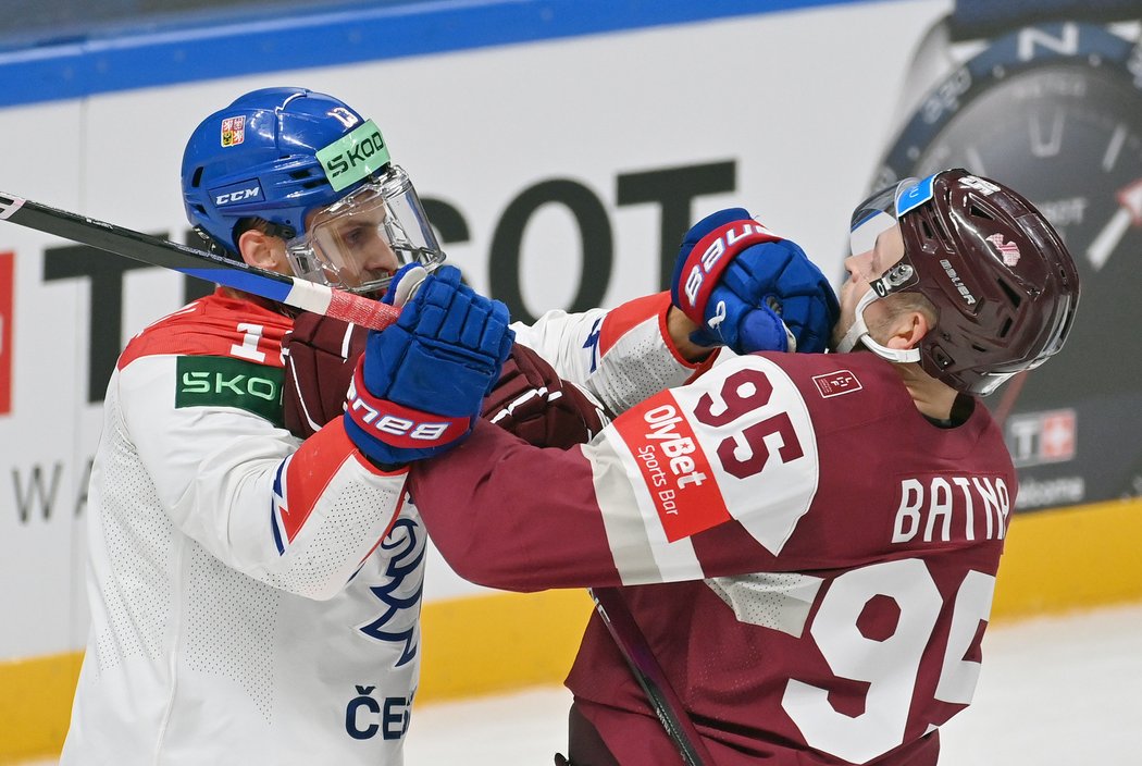 Český útočník Jiří Smejkal v potyčce s Oskarsem Batnou z Lotyšska