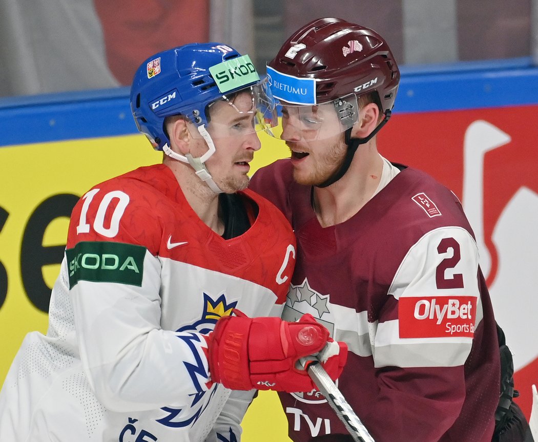 Kapitán hokejové reprezentaci Roman Červenka při střetu s Karlisem Čukstem z Lotyšska