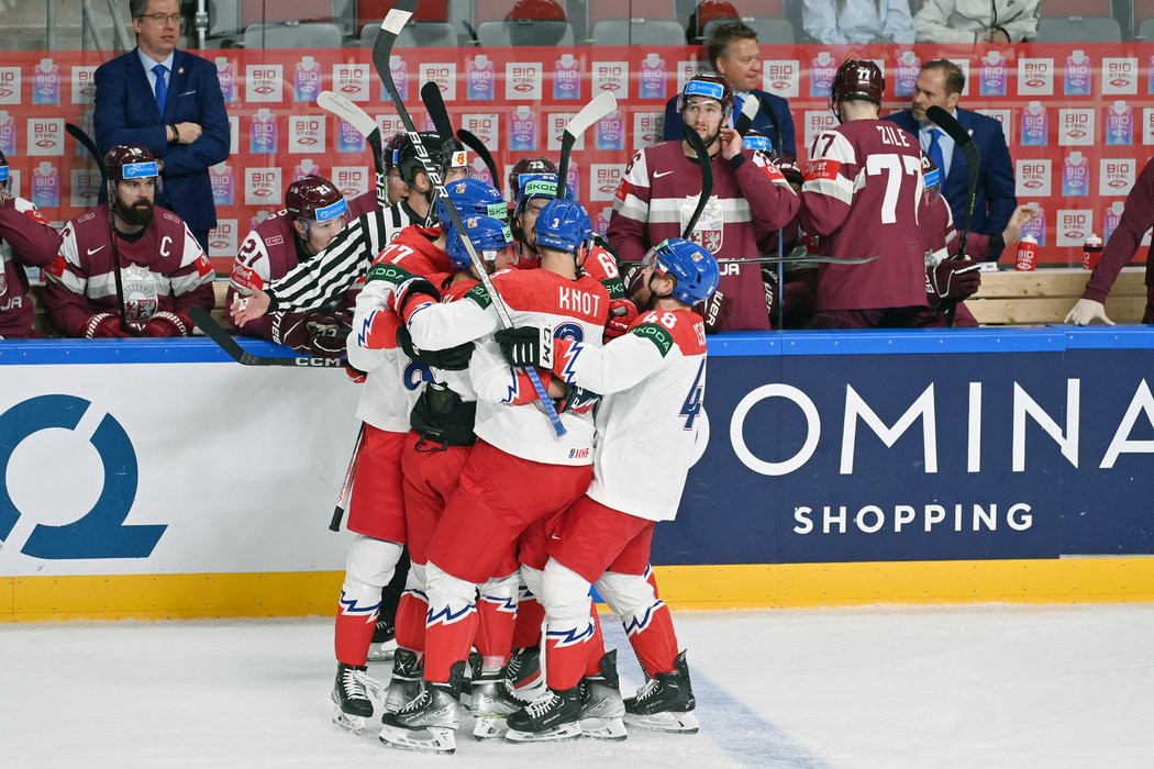 Čeští hokejisté se radují z gólu před lotyšskou střídačkou