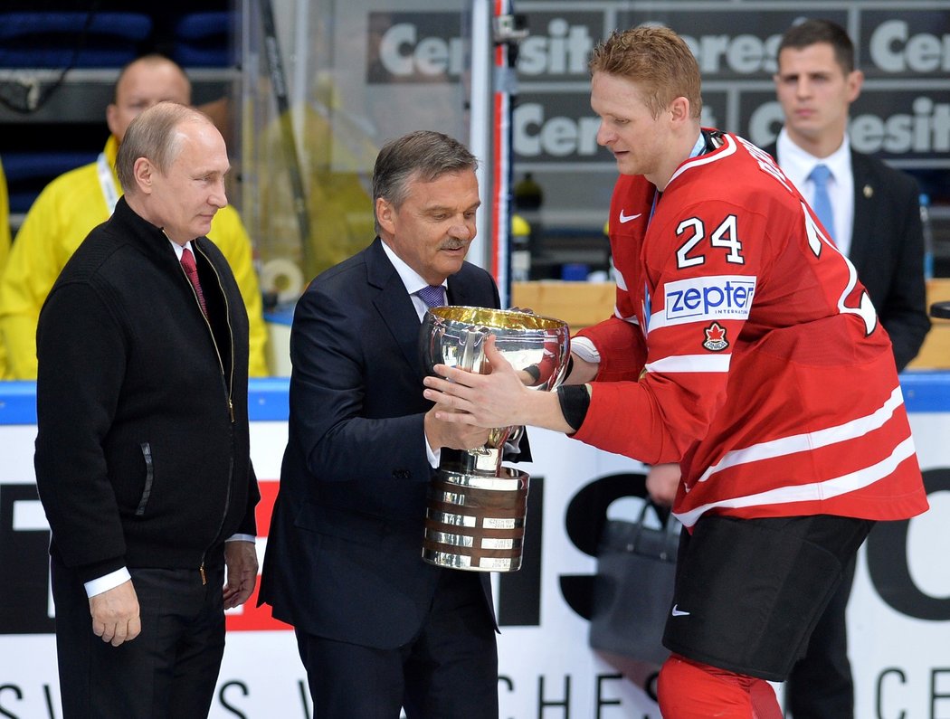 Vladimir Putin v roce 2016 asistoval Renému Faselovi při předání poháru pro mistry světa kanadskému kapitánovi Coreymu Perrymu