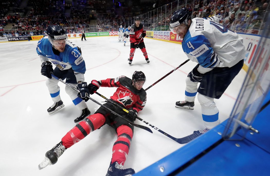 Kanadský útočník Anthony Cirelli skončil v souboji u mantinelu se dvěma finskými protihráči na ledě