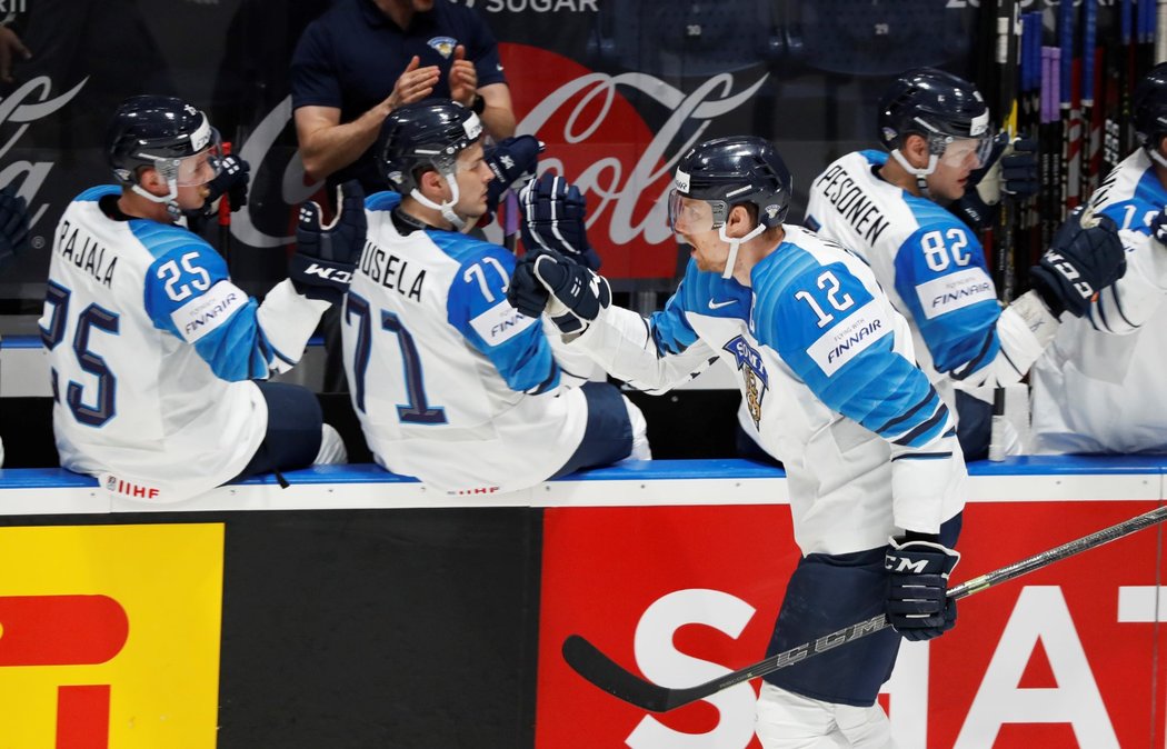 Obrovitý finský kapitán Marko Anttila se raduje se spoluhráči z vyrovnávací branky ve finále proti Kanadě
