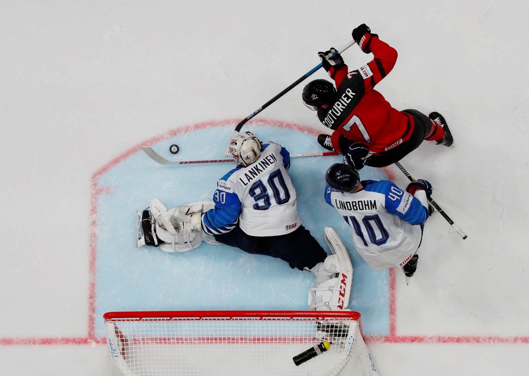 Finský gólman Kevin Lankinen si dává pozor na výpad kanadského útočníka Seana Couturiera před brankou