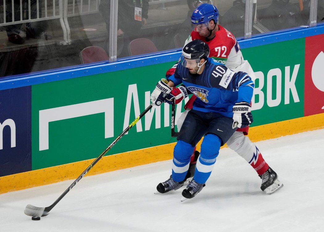 Filip Chytil se snaží dostat ke kotouči přes Petteriho Lindbohma