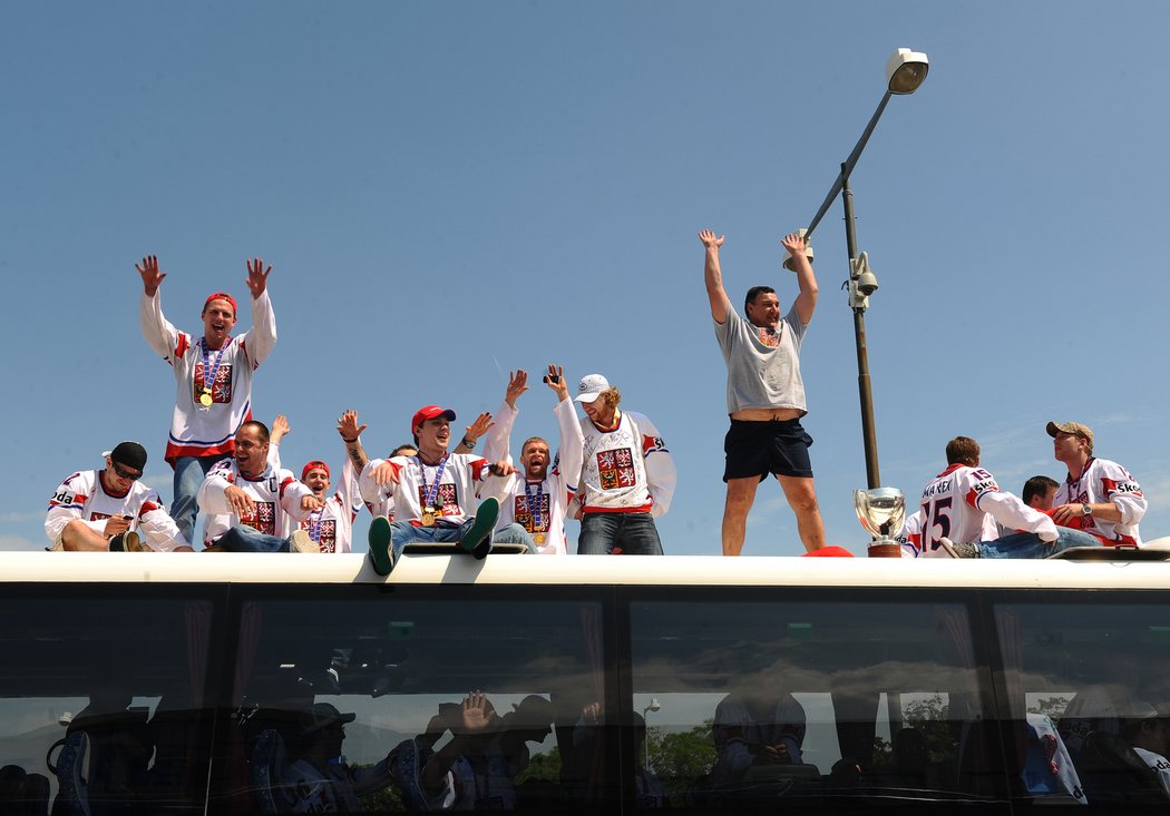 Slavící hokejisté na střeše autobusu