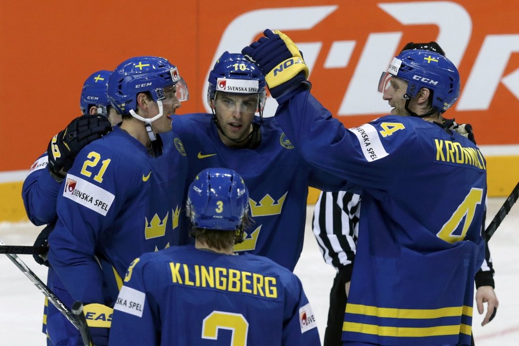Hokejisté Švédska se radují z gólu do sítě Lotyšska