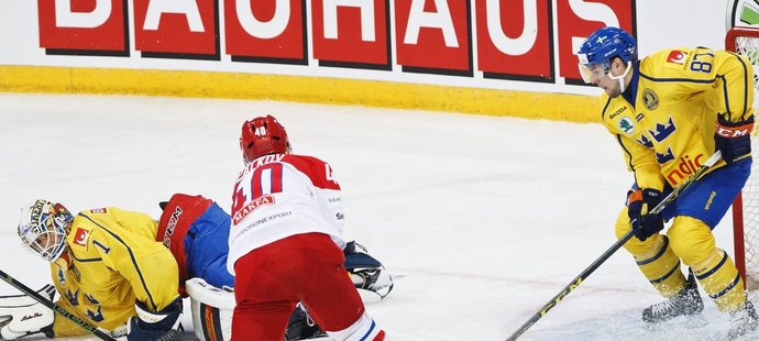 Ruský hokejista Daniil Apalkov otevírá skóre v zápase se Švédskem na Karjale, sleduje ho brankář Henrik Karlsson, Robert Rosen jeho střele také nezabránil...