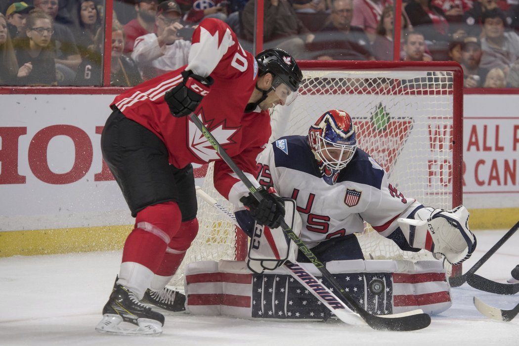 John Tavares se snaží prosadit před brankářem Cory Schneiderem