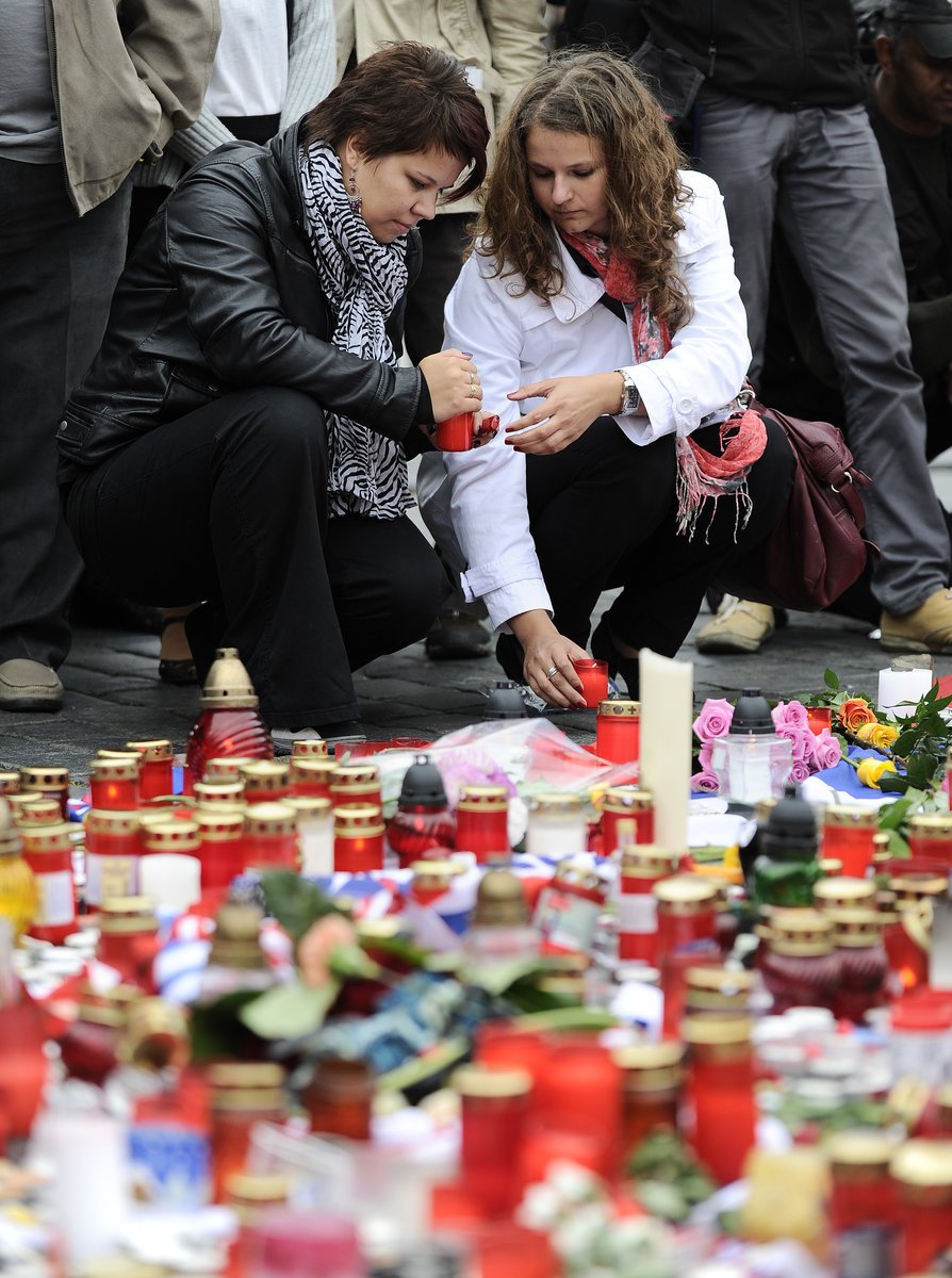 Smutné fanynky zapalují svíčku za Jana Marka, Josefa Vašíčka a Karla Rachůnka na Staroměstském náměstí