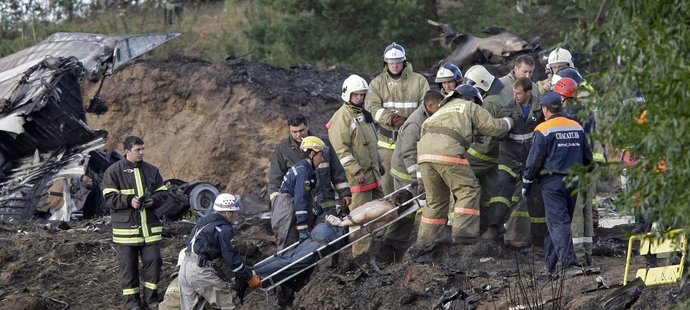 Záchranáři z trosek zříceného letounu Jaroslavle odnášejí jednu z obětí