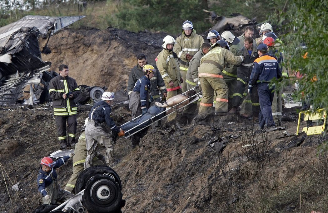 Záchranáři z trosek zříceného letounu Jaroslavle odnášejí jednu z obětí