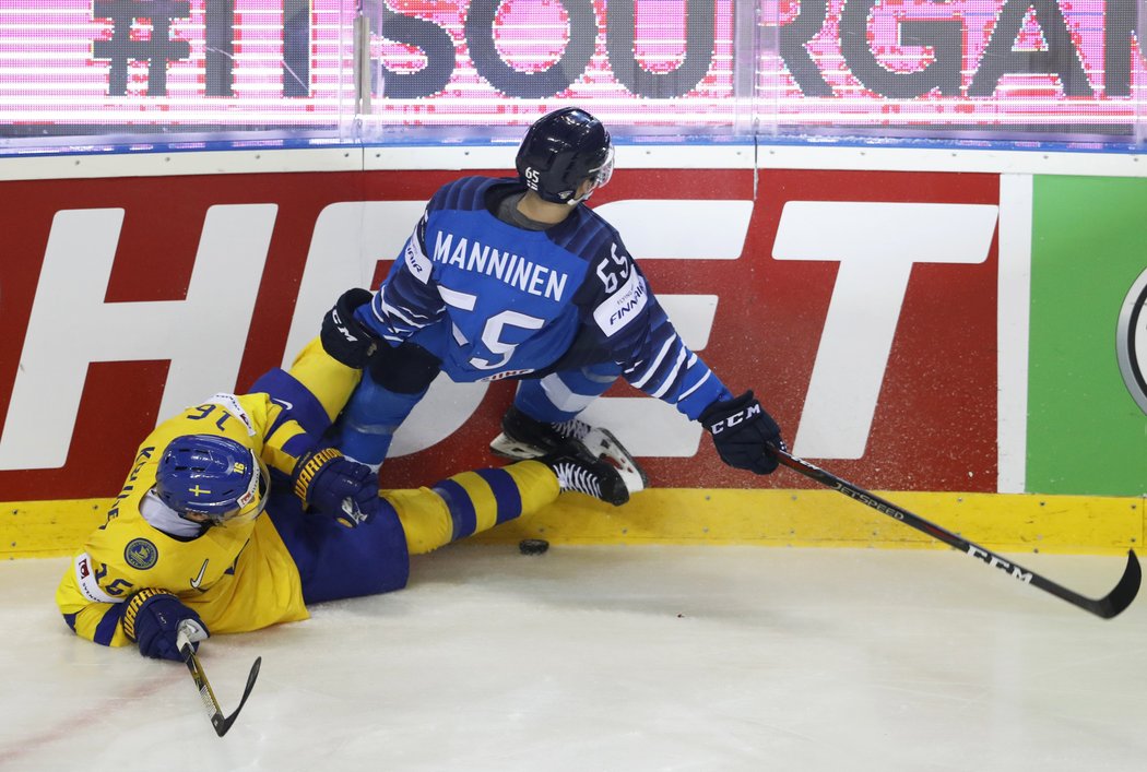 Švéd Marcus Kruger a Sakari Manninen v drsném střetu u mantinelu během čtvrtfinále MS v Košicích.