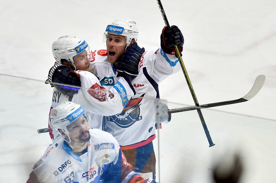 Radující se dvojice Jan Stránský (vlevo), Radek Duda (vpravo) v zápase Chomutov - Kometa Brno. V popředí smutný obránce Ondřej Němec