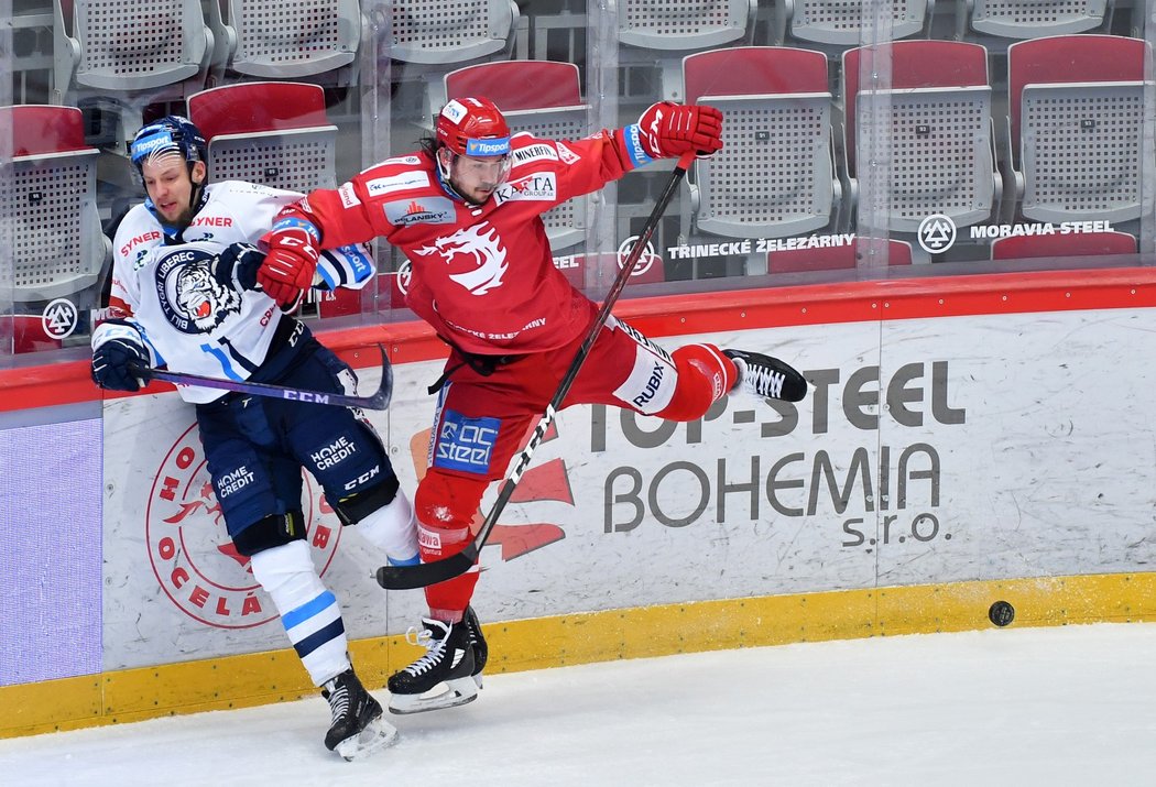 Třinecký obránce Tomáš Kundrátek naráží na mantinel libereckého beka Tomáše Havlína