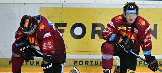 Filip Chlapík (vlevo) a Maxim Matuškin zklamaně hledí do ledu po konci finále