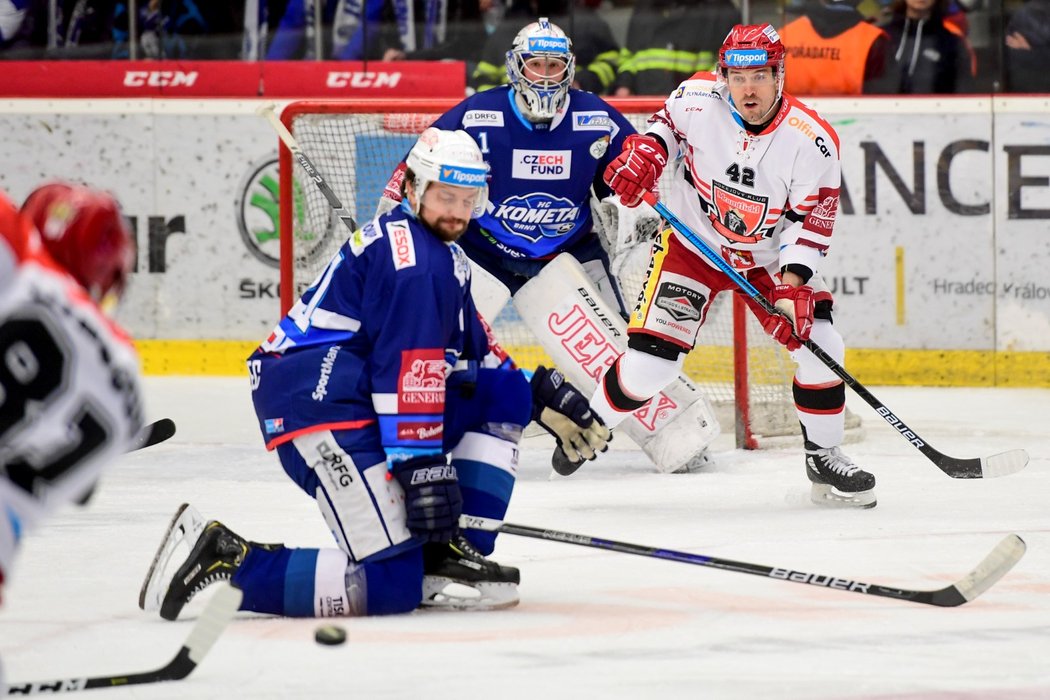 Tomáš Malec (uprostřed) blokuje střelu Tomáše Vincoura (v popředí). Brankář Marek Čiliak a před ním stojící Petr Koukal během druhého čtvrtfinále mezi Hradcem a Kometou čekají, jestli puk projde