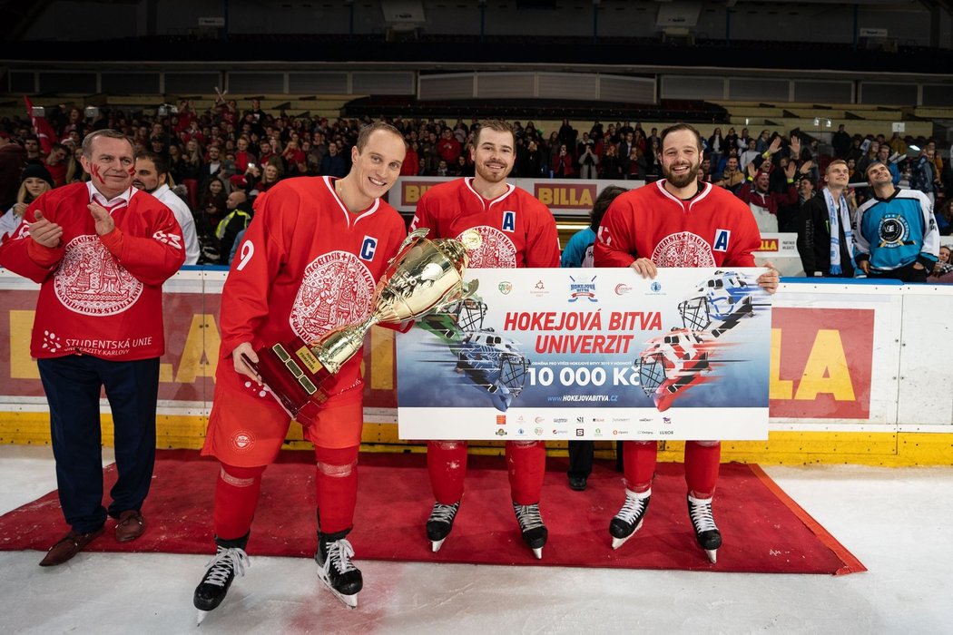 Lídři hokejového týmu Univerzity Karlovy přebírají trofej pro vítěze a částku 10 tisíc korun