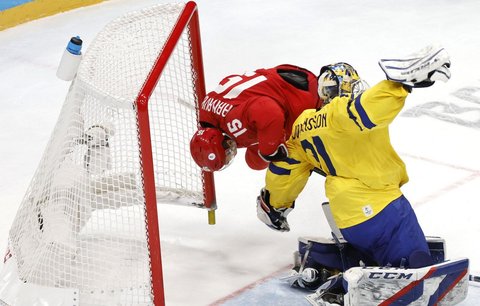 Pavel Karnauchov z Ruska přepadává přes švédského brankáře Larse Johanssona v semifinále olympijského turnaje