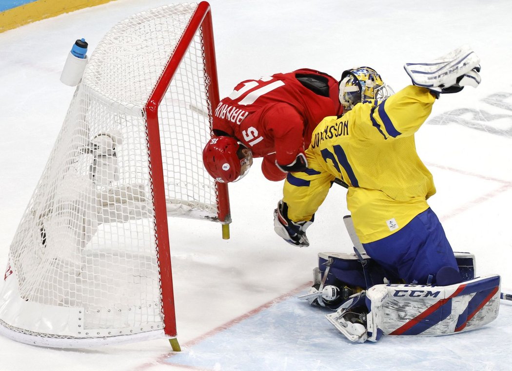 Pavel Karnauchov z Ruska přepadává přes švédského brankáře Larse Johanssona v semifinále olympijského turnaje