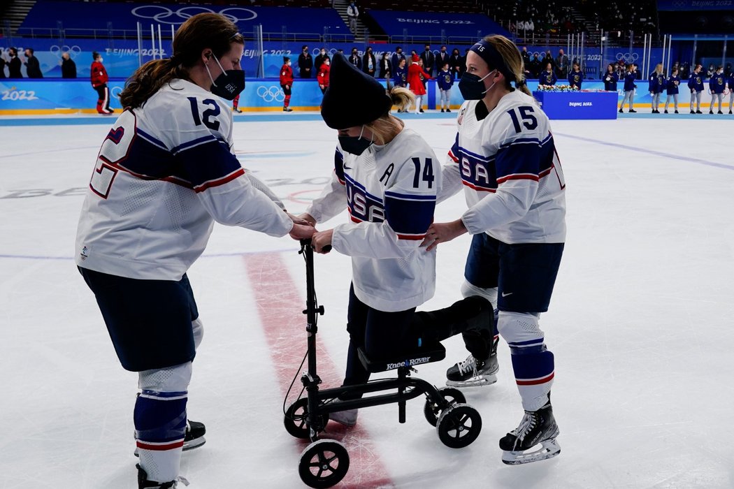 Spoluhráčky pomáhají zraněné Američance Brianně Deckerové na medailový ceremoniál po finálové porážce