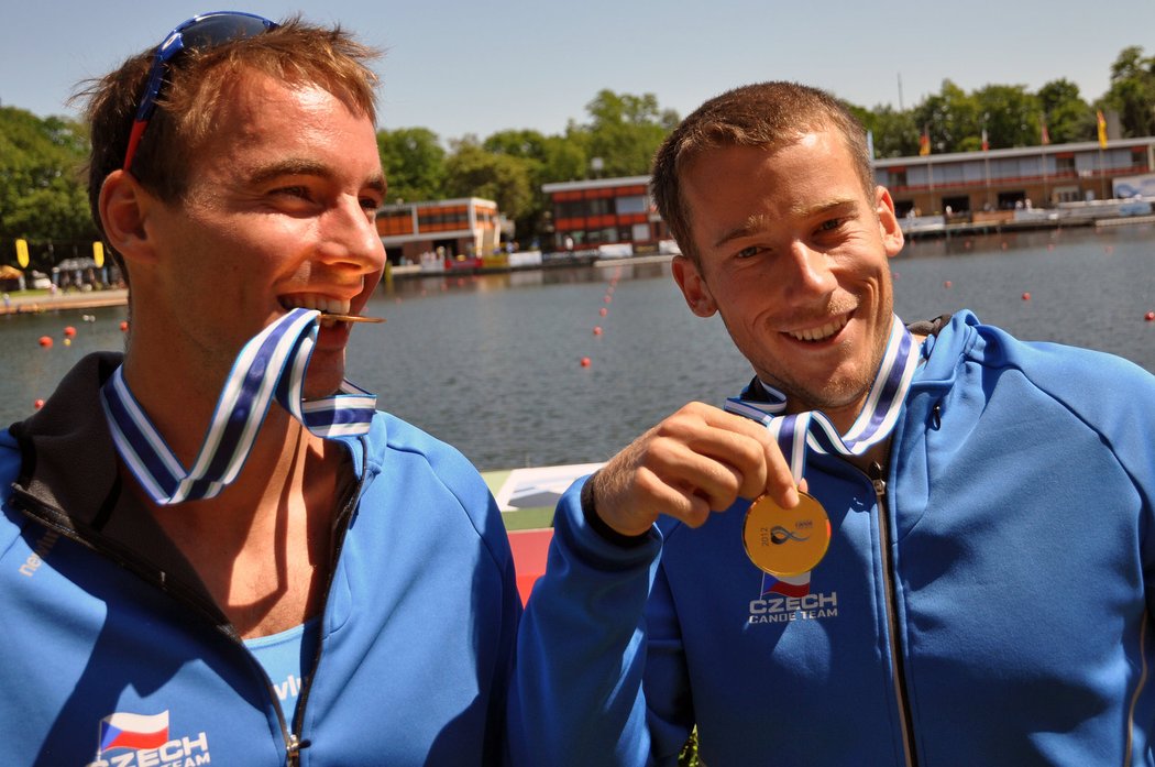 Filip Dvořák kouše zlatou medaili, kterou získal společně s Jaroslavem Radoněm (vpravo) za vítězství v závodu Světového poháru rychlostních kanoistů v německém Duisburgu.