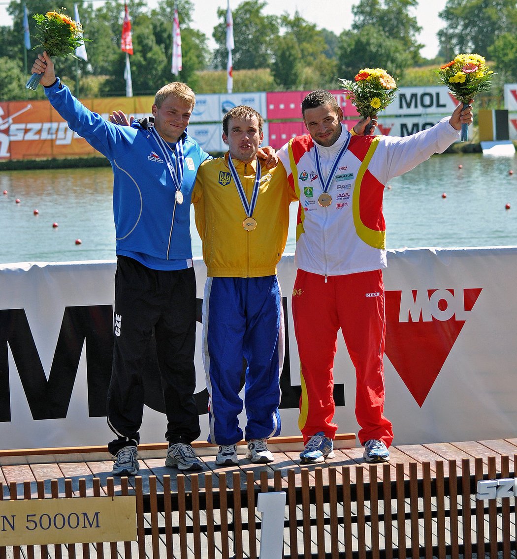 Český reprezentant Lukáš Koranda pózuje na stupních vítězů s vítězem Michailem Košmanem z Ukrajiny a bronzovým Španělem Josem Luisem Bouzou (zleva) po závodě na 5000 metrů na mistrovství světa v rychlostní kanoistice v maďarském Szegedu.