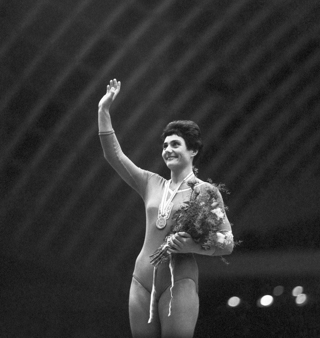 Olympijská vítězka Eva Bosáková mává pražskému publiku se zlatou medailí mistryně světa na kladině v roce 1962. Poprvé se stala šampionkou o čtyři roky dřív v Moskvě, kde ve finále prostných překonala strach a skočila salto vzad, které stojí v názvu povídky Oty Pavla.