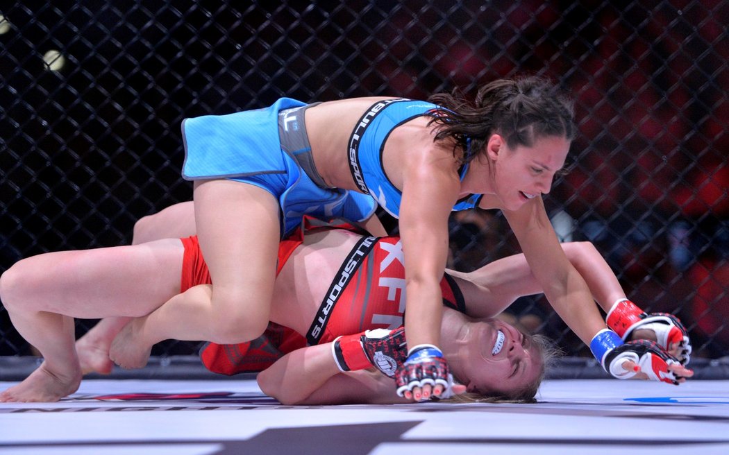 Česká MMA zápasnice Sandra Mašková (v červeném) je pod útok soupeřky Camily Rivaroly