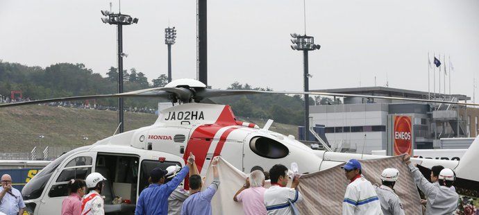 Záchranáři transportují Alexe de Angelise do helikoptéry po jeho nehodě ve Velké ceně Japonska