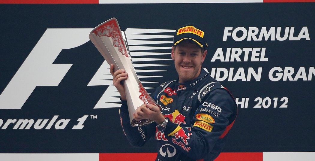 Vítězný Vettel se raduje s trofejí.