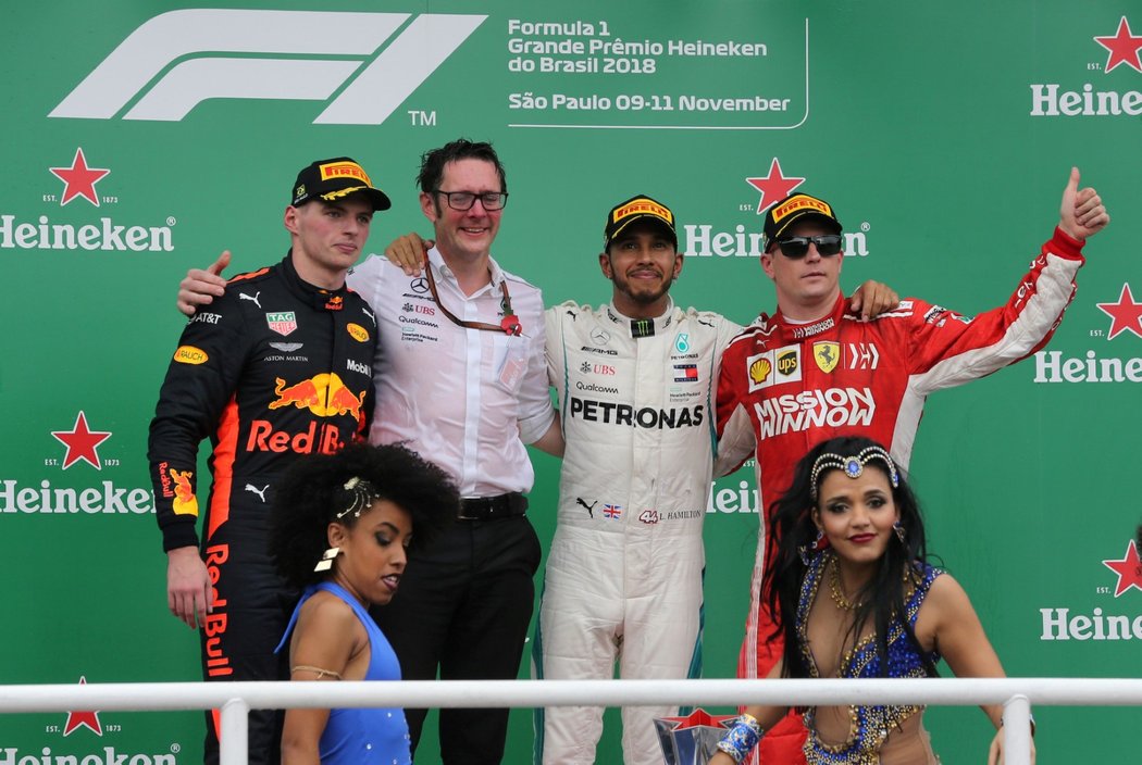 Stupně vítězů při Velké ceně Brazílie: zleva druhý Max Verstappen, traťový ředitel Mercedesu Andrew Showlin, vítězný Lewis Hamilton a třetí Kimi Räikkönen
