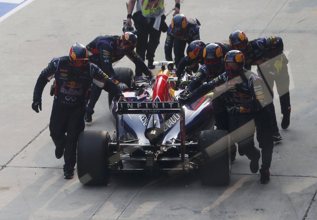 Mechanici Red Bullu tlačí do boxů porouchaný vůz Daniela Ricciarda.